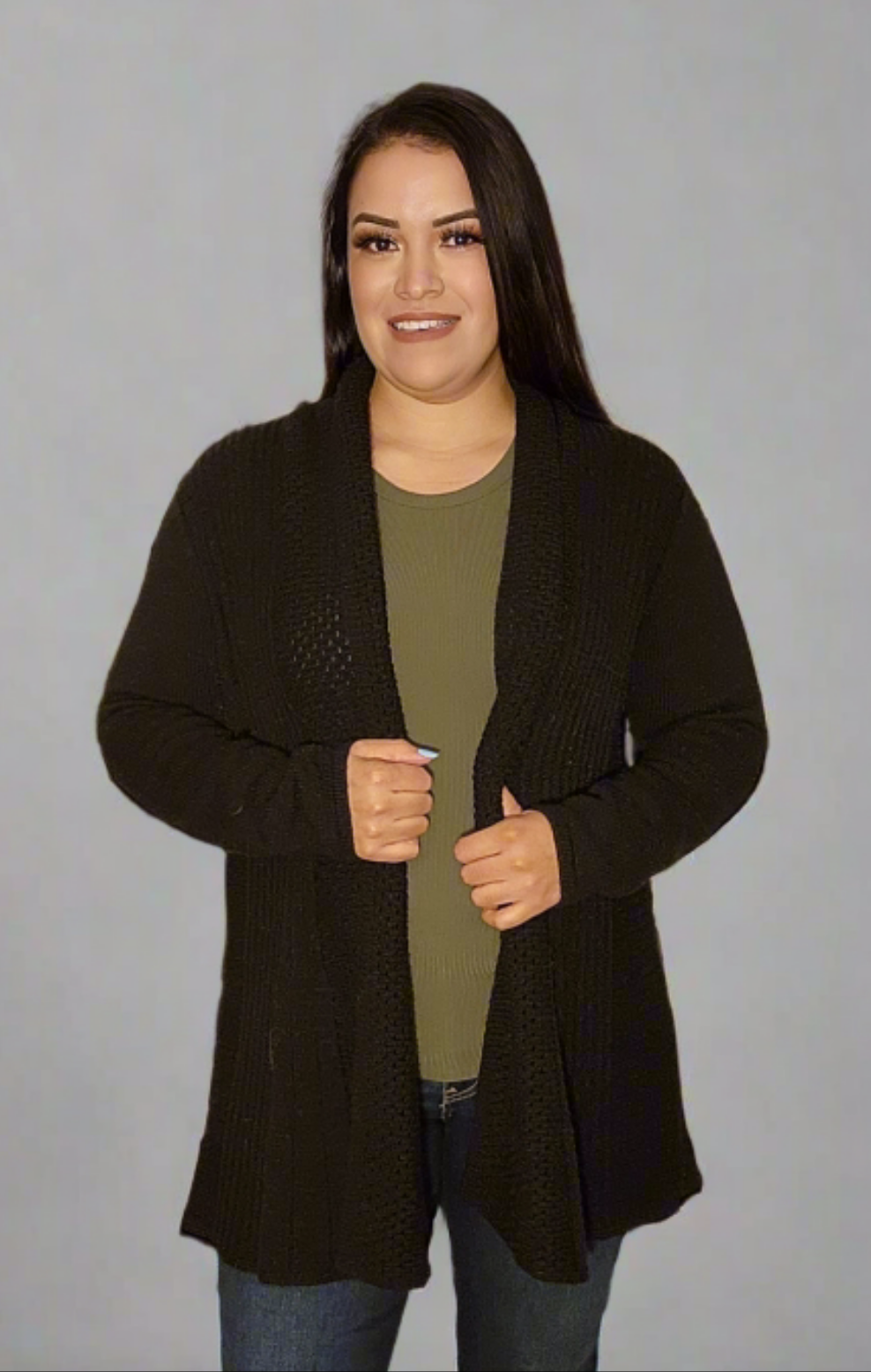 Woman wearing a dark brown cardigan over a green shirt on a gray background