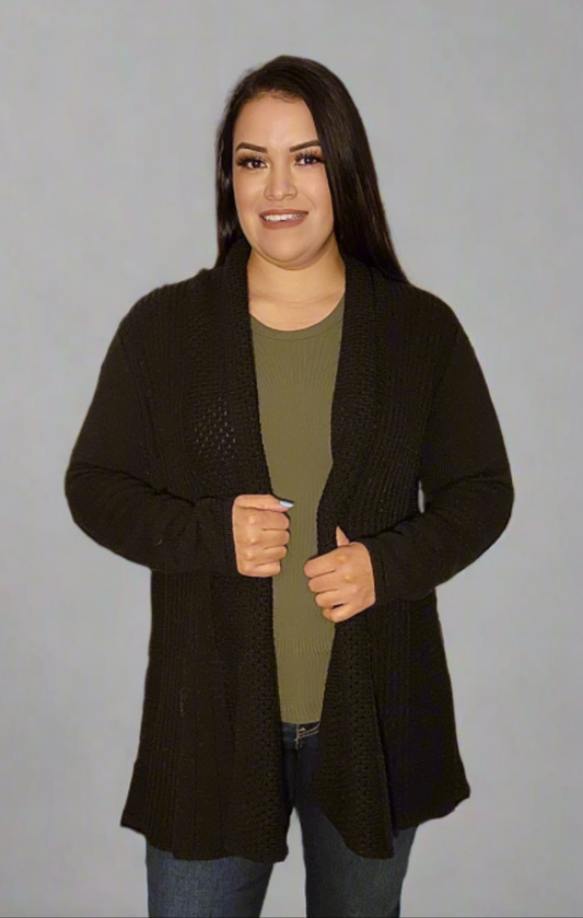 Woman wearing a dark brown cardigan over a green shirt on a gray background