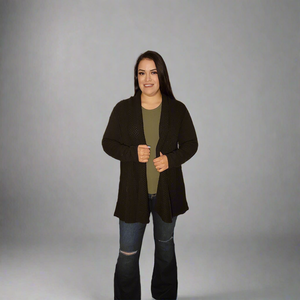 Woman wearing a black coat over a green shirt on a gray background