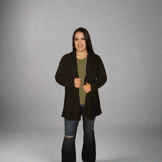 Woman wearing a black coat over a green shirt on a gray background