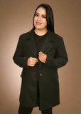 Woman wearing a black coat against a brown background