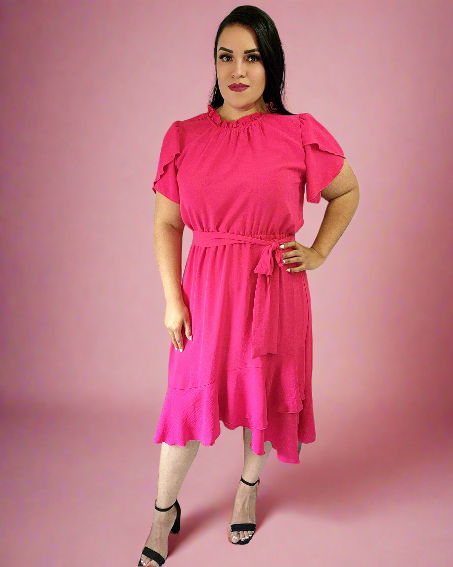 Woman wearing a bright pink dress against a pink background