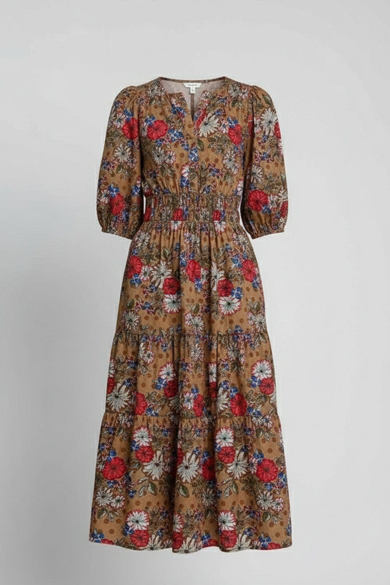 Woman wearing a floral dress with a brown mix pattern on a plain background