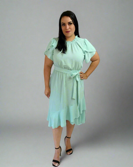 Woman wearing a light green dress against a plain background
