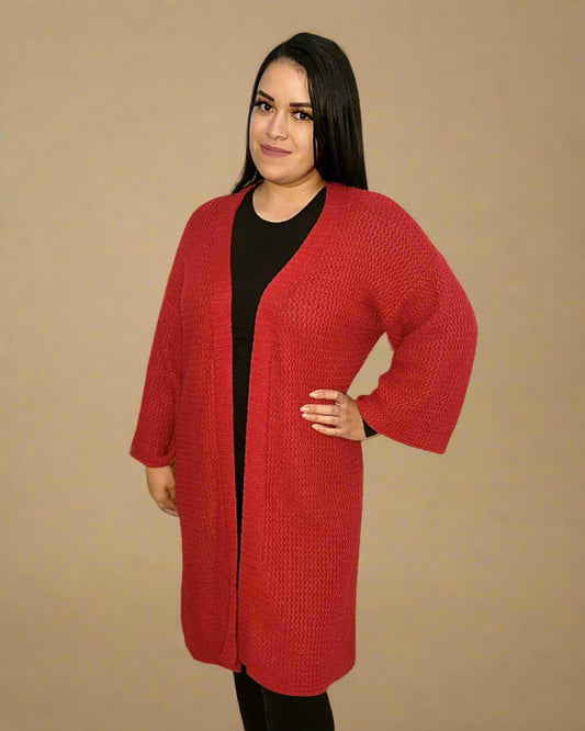 Woman wearing a red cardigan over a black top on a beige background
