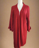 Red knitted cardigan on a mannequin against a plain background