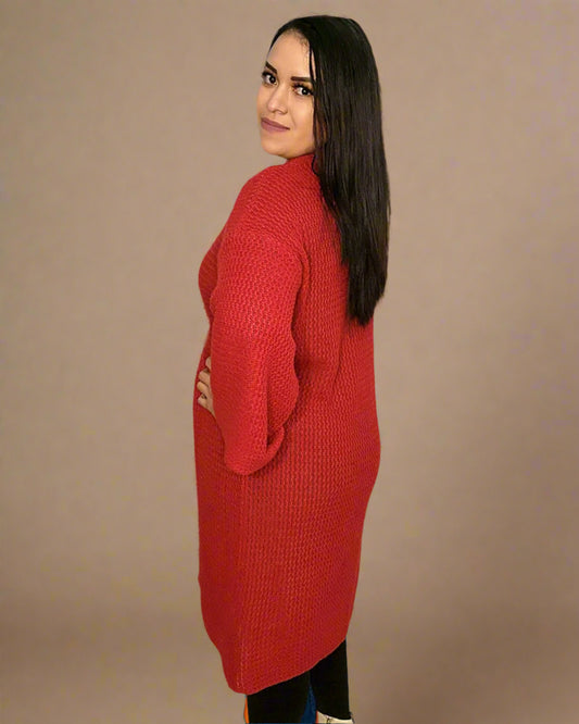 Woman wearing a red knitted dress against a beige background