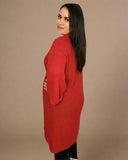 Woman wearing a red knitted dress against a beige background