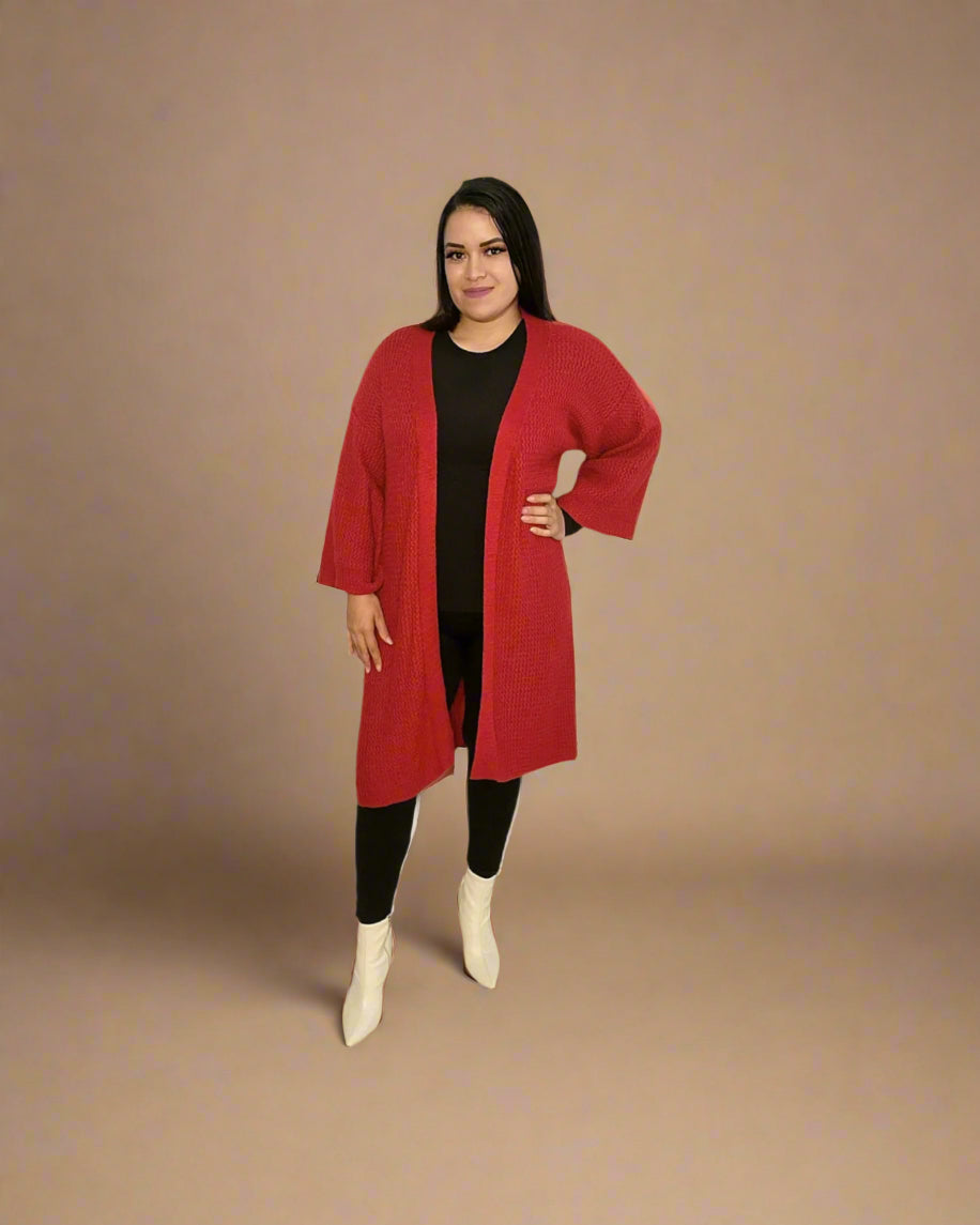 Woman wearing a red coat, black top, and white boots on a beige background